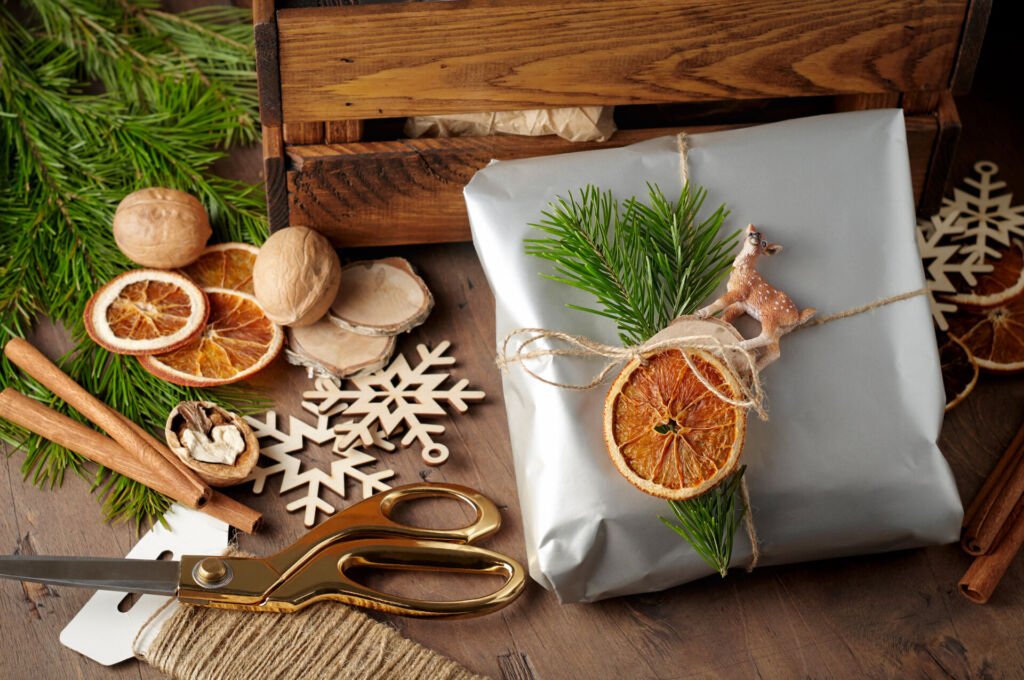 Packaging christmas present handmade gift boxes decorated with silver paper with dried orange slices